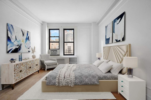 bedroom featuring cooling unit and wood finished floors