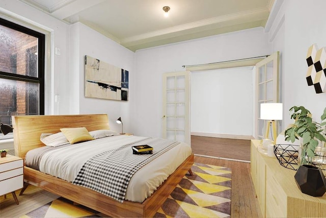 bedroom featuring wood finished floors and ornamental molding