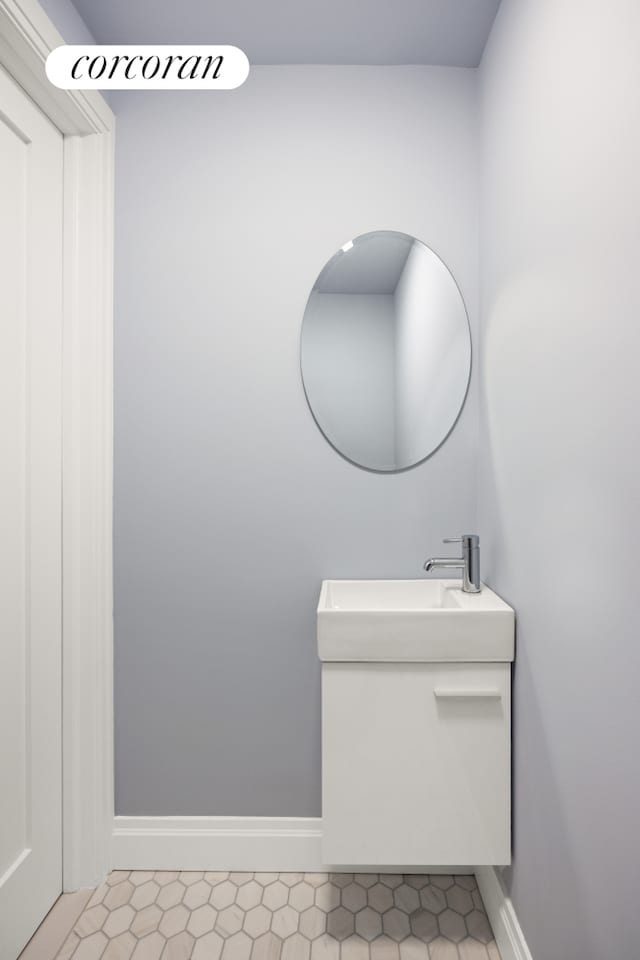 bathroom featuring baseboards, tile patterned floors, and vanity