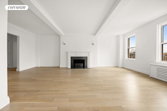 unfurnished living room with visible vents, a fireplace with flush hearth, baseboards, and light wood finished floors