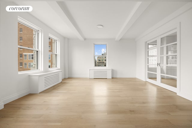 spare room with light wood-style floors, baseboards, and beamed ceiling