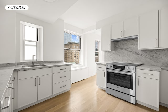kitchen featuring a sink, electric stove, white cabinetry, decorative backsplash, and under cabinet range hood