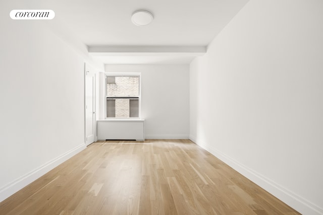 empty room featuring visible vents, baseboards, and light wood finished floors