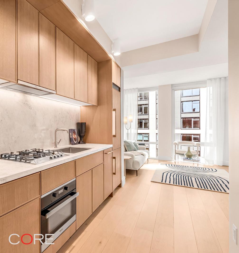 kitchen featuring under cabinet range hood, backsplash, open floor plan, appliances with stainless steel finishes, and light countertops