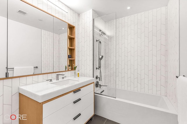 full bath with visible vents, tile walls, tile patterned flooring, shower / bath combination, and vanity