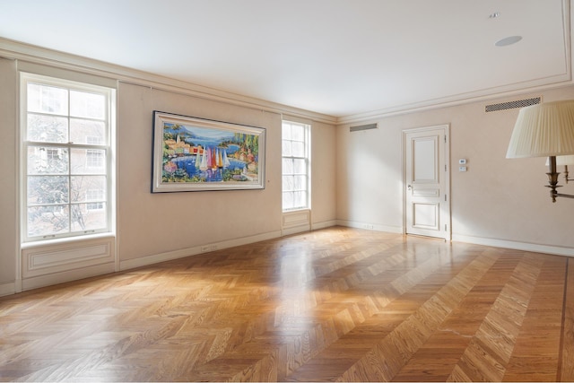 empty room featuring visible vents, baseboards, and crown molding