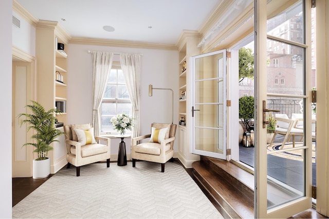 sitting room featuring crown molding, built in features, baseboards, and dark wood-style floors
