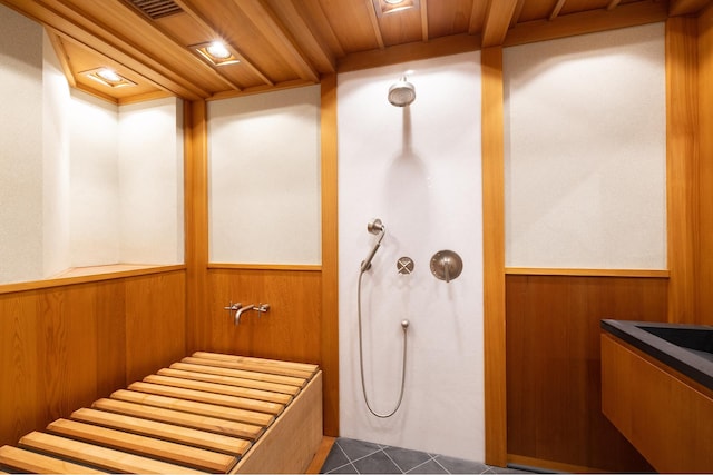 bathroom with wooden ceiling, wood walls, wainscoting, and tile patterned flooring