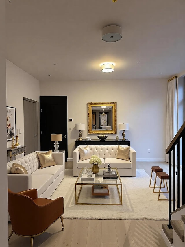 living room with baseboards, light wood-style flooring, and stairs