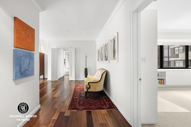 hallway featuring baseboards, hardwood / wood-style floors, and crown molding