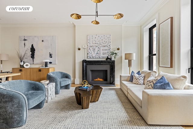 living area featuring baseboards, visible vents, a lit fireplace, and ornamental molding