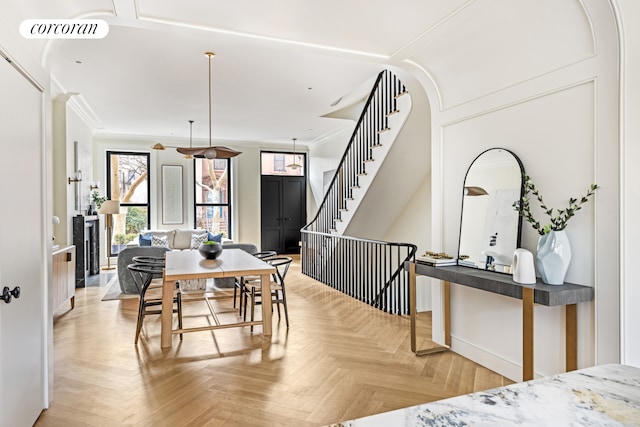 dining area featuring arched walkways, visible vents, stairway, and ornamental molding