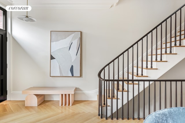 staircase featuring visible vents and ornamental molding