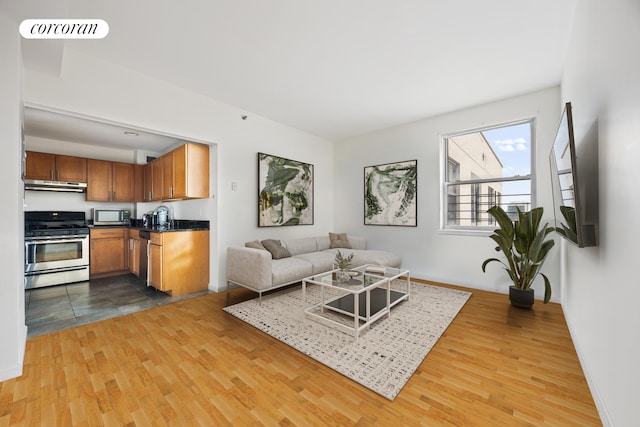 living room with visible vents, baseboards, and wood finished floors