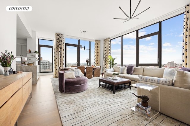 living room featuring visible vents, a wall of windows, and light wood-style floors