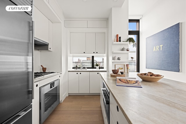 kitchen with gas cooktop, plenty of natural light, light countertops, and stainless steel fridge