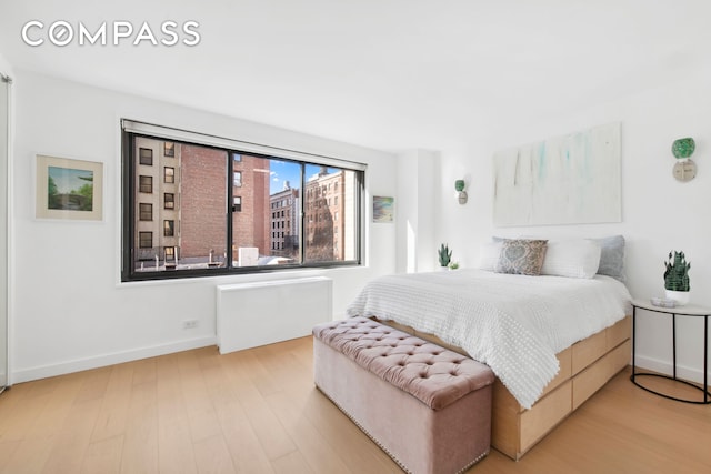 bedroom with light wood finished floors and baseboards