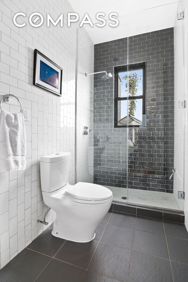 full bathroom with tile patterned floors, toilet, tile walls, and a shower stall