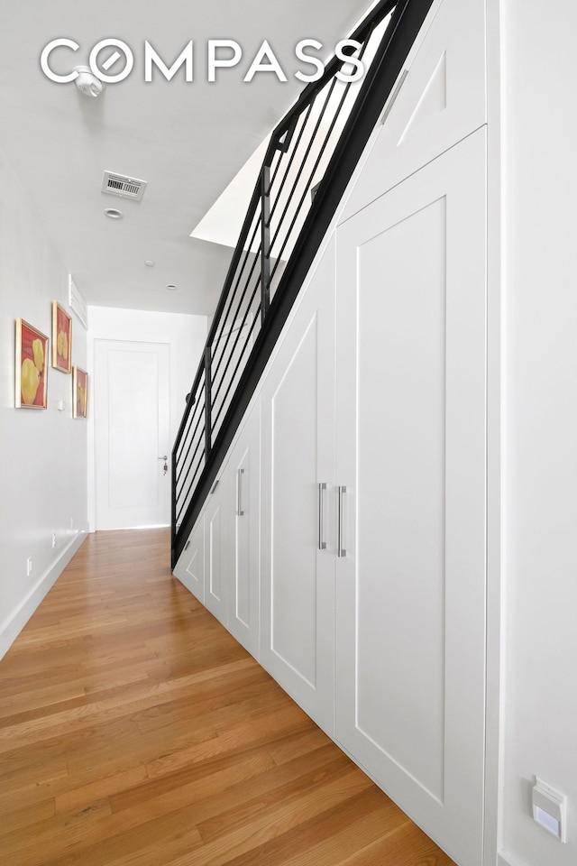 hall featuring light wood finished floors and stairway
