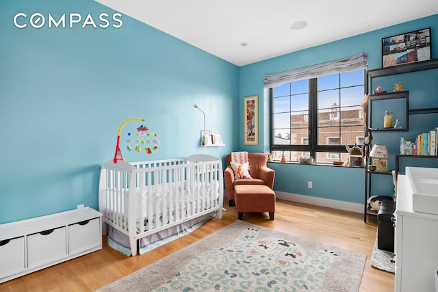 172 Wilson Ave Pha, Pha, New York City, NY 11237 - bedroom with wood finished floors, baseboards, and a nursery area