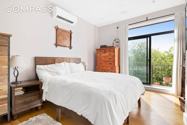 bedroom with multiple windows, a wall mounted AC, and wood finished floors