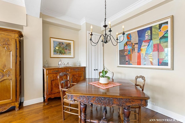 dining area featuring dark wood-style floors, a notable chandelier, baseboards, and ornamental molding