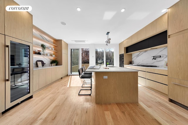 kitchen with modern cabinets, light brown cabinets, and a sink