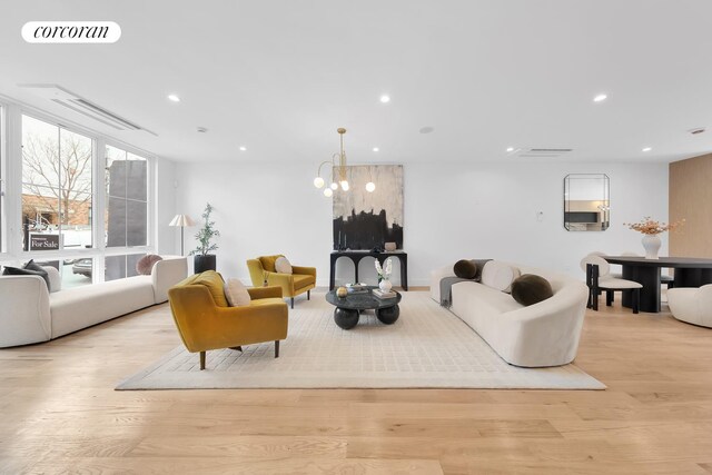 living area with recessed lighting, visible vents, and light wood-style flooring