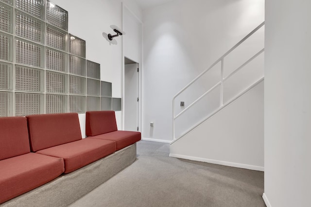 living room featuring baseboards, carpet, and a towering ceiling