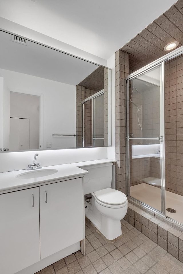 bathroom featuring a stall shower, toilet, and vanity