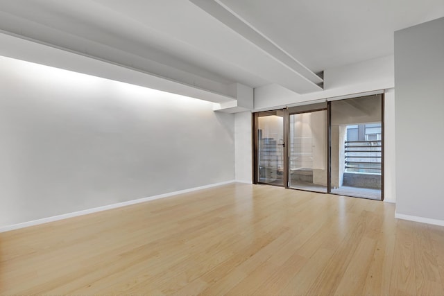 empty room featuring wood finished floors and baseboards
