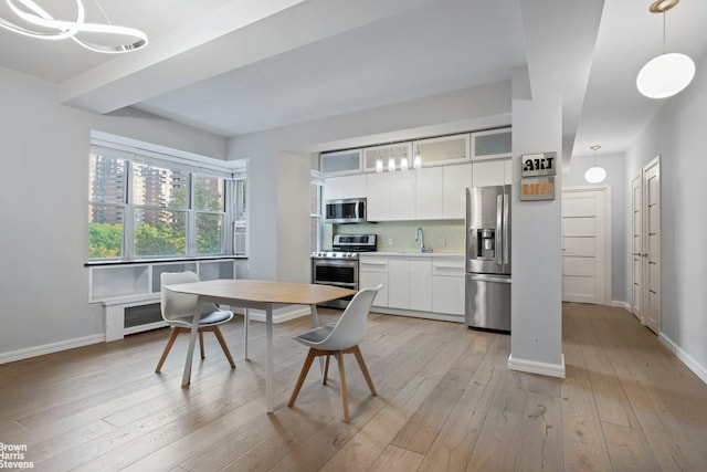 dining space featuring light wood-type flooring and baseboards