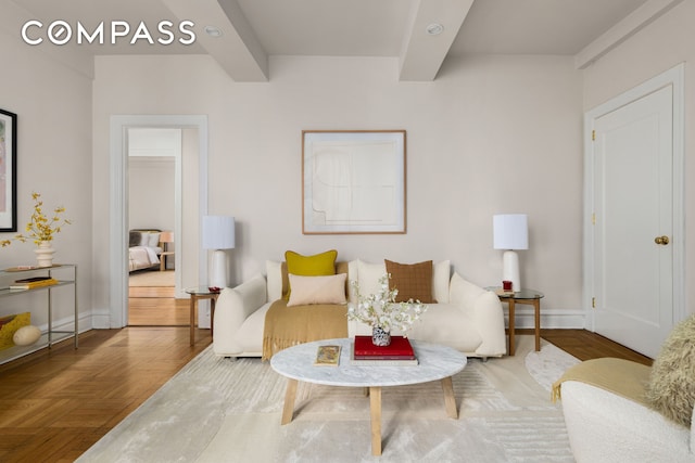 living area with baseboards and beam ceiling