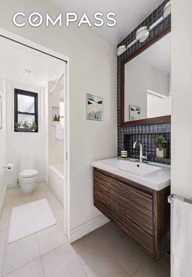 bathroom featuring baseboards, shower / washtub combination, toilet, tile patterned floors, and vanity