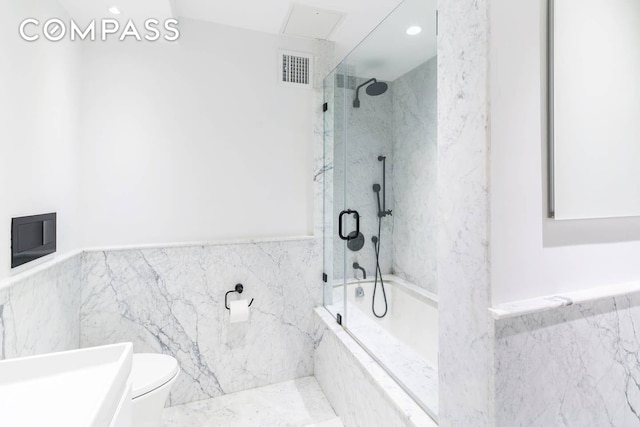 full bath with combined bath / shower with glass door, visible vents, toilet, and tile walls