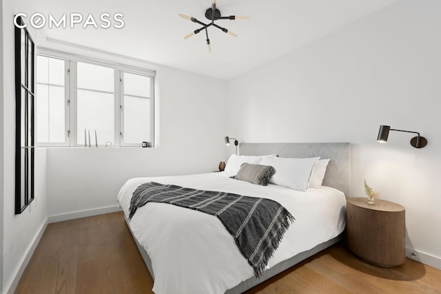 bedroom with wood finished floors and baseboards