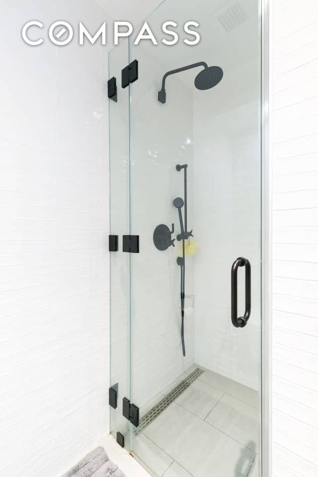 bathroom with tile patterned floors and a stall shower