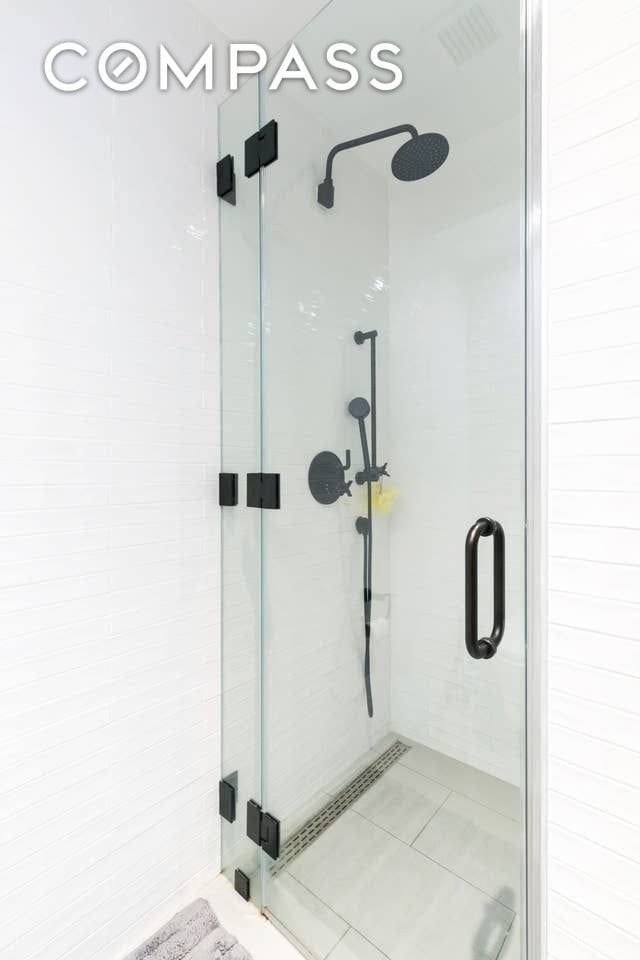 full bath featuring a shower stall and tile patterned flooring