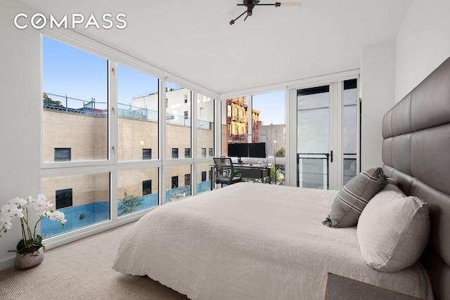 bedroom featuring expansive windows, multiple windows, and carpet floors