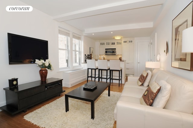 living area with visible vents and wood finished floors