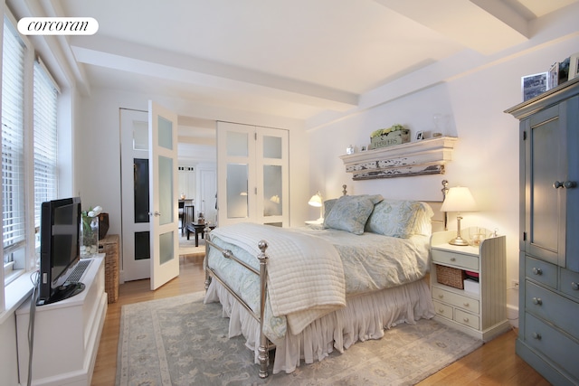 bedroom with beam ceiling, visible vents, french doors, and light wood-type flooring