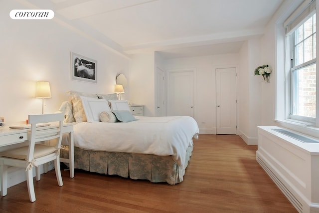 bedroom featuring visible vents, baseboards, and wood finished floors