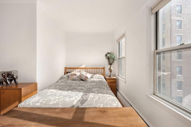 bedroom with a baseboard radiator and ornamental molding