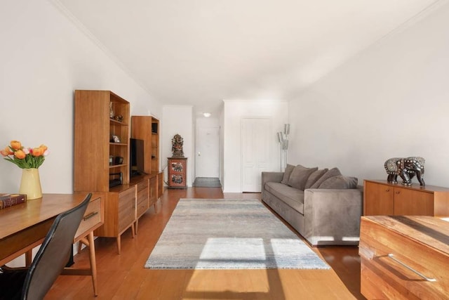 living area with wood finished floors and ornamental molding