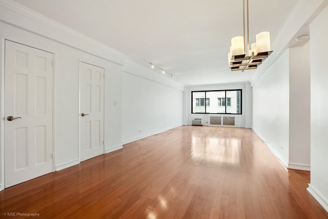 unfurnished living room featuring light wood-style floors, baseboards, and ornamental molding