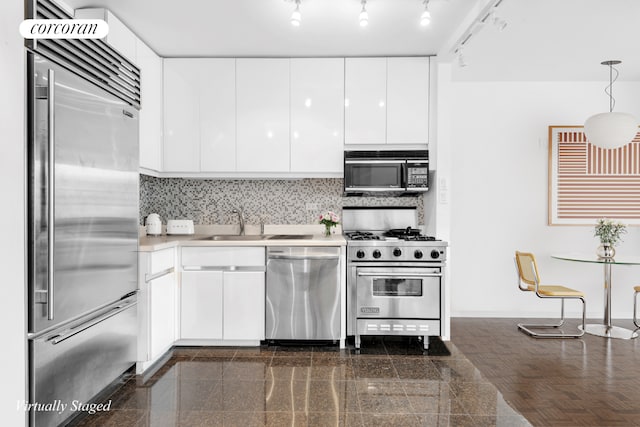 kitchen with granite finish floor, white cabinets, high end appliances, and backsplash