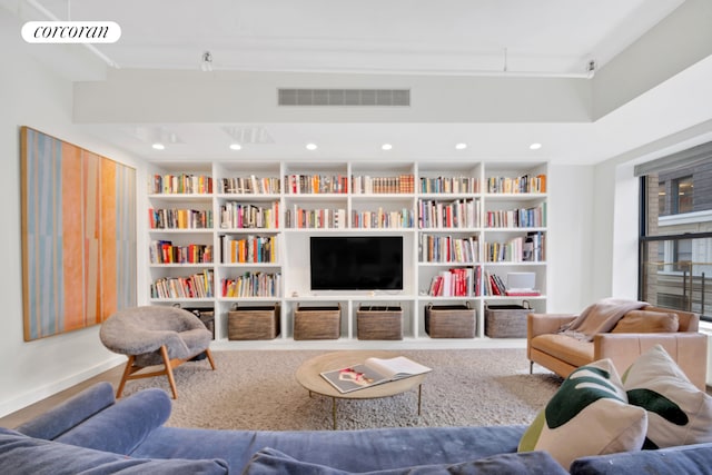 living room featuring built in features, visible vents, and recessed lighting