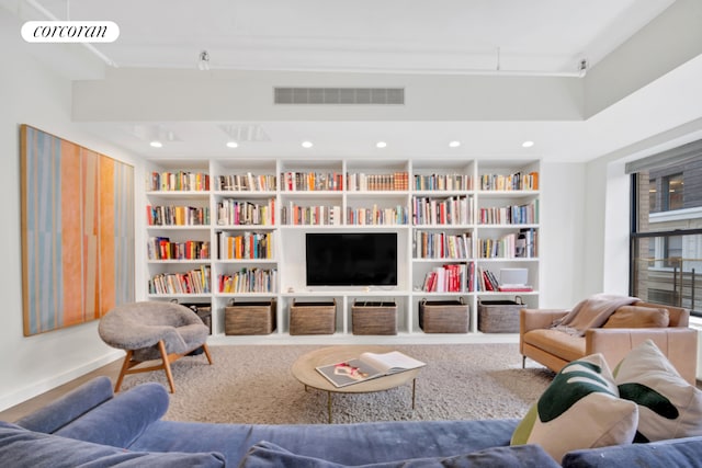 12 W 18th St Unit 4E, New York City, NY 10011 - living room with built in shelves, baseboards, and wall of books