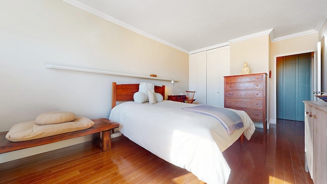 bedroom with a closet, ornamental molding, and hardwood / wood-style flooring