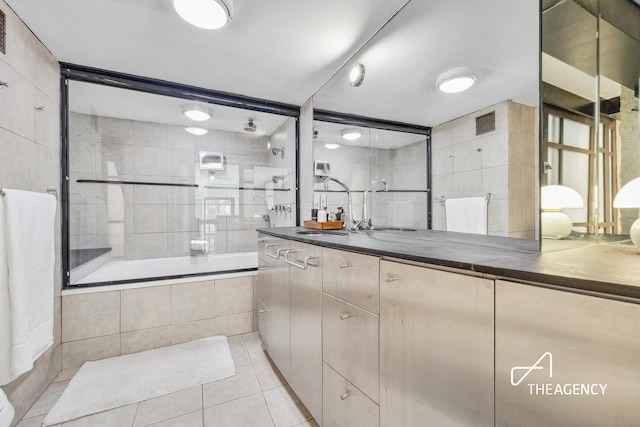 full bathroom with visible vents, tiled shower / bath combo, tile walls, tile patterned flooring, and vanity